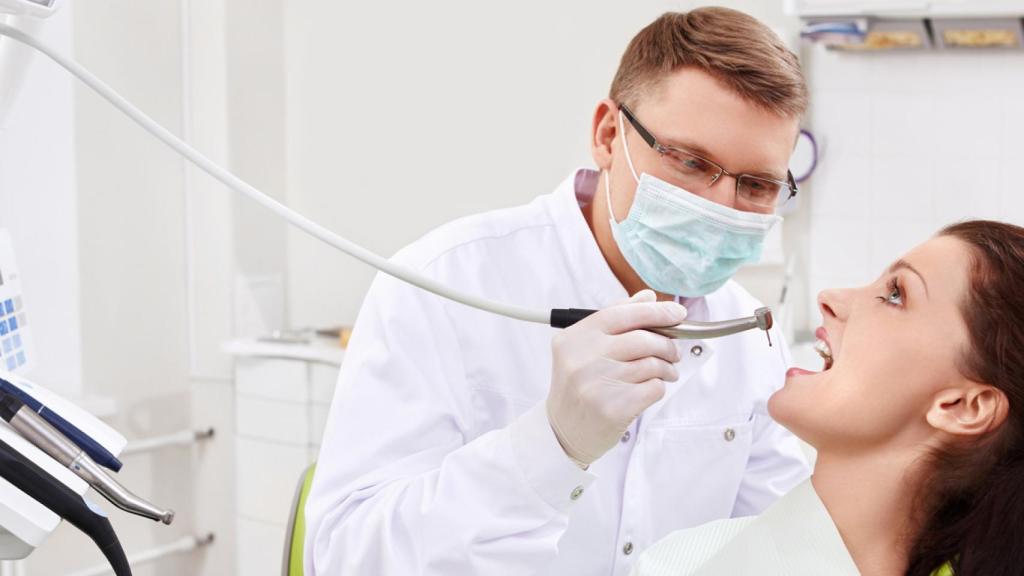 Un dentista atiende a una paciente.