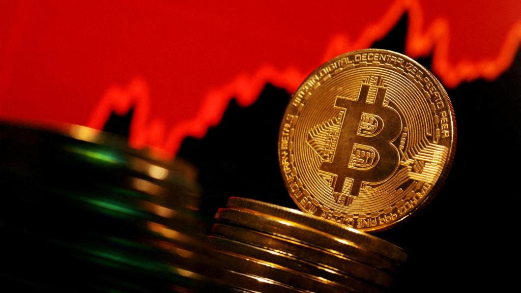 Representación física de varios bitcoin sobre un gráfico de cotización ascendente.