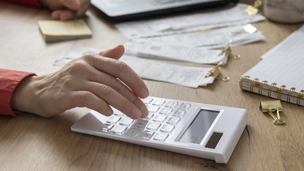 Una persona hace cuentas con una calculadora.