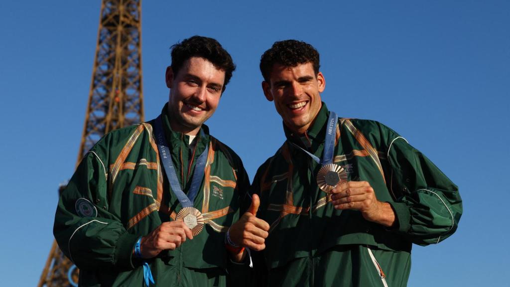 Daire Lynch y Philip Doyle posan con las medallas y la Torre Eiffel de fondo.