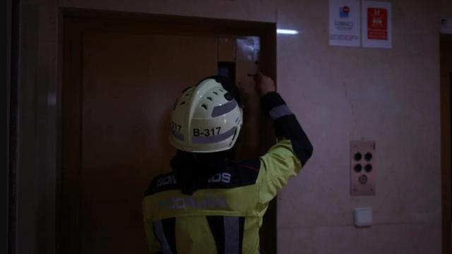 Un bombero trata de abrir un ascensor averiado por el apagón en A Coruña.