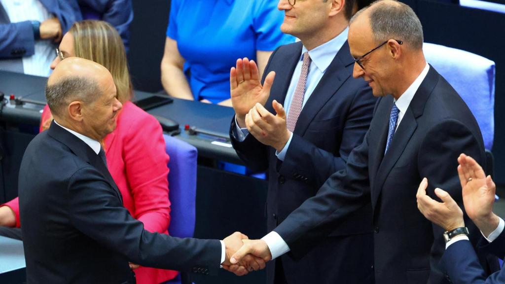 El canciller saliente, Olaf Scholz, saluda al nuevo jefe de Gobierno alemán, Friedrich Merz, este martes en el Bundestag tras su elección en segunda votación.